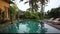 The pool and sun loungers in the Villa on the background of palm trees