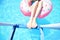 Pool time. Female legs holding ladder in a swimming pool