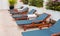 Poolside deckchairs with blue swimming pool