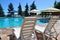 Poolside. Sunbeds near swimming pool surrounded by pine trees