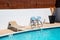 Poolside with sunlounger and chairs for recreation at outdoor backyard pool in summer