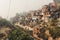 Poor area of Haridwar, India. House poor people on the hillside in front of a dirty river.