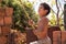 A poor boy playing with a bamboo pole outside his poor home