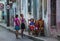 Poor Cuban old people capture portrait in traditional colorful colonial alley with old life style, in old city, Cuba, America.