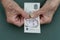 Poor elderly woman is counting some Singapore dollars in her hand. wrinkled Hands of an old woman. Counting money, economy concept