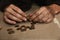 Poor homeless man counting coins on floor