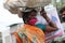 Poor Indian woman loads luggage on her head wearing mask due to corona virus disease .