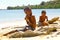 Poor malagasy boy breaking coconuts on the beach