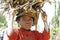 Poor malagasy boy carrying branches on his head