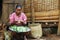 Poor Malagasy woman preparing food in front of cabin