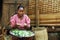 Poor Malagasy woman preparing food in front of cabin