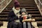 Poor mother and daughter with bread sitting on stairs