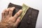 Poor pensioner torn wallet with one dollar