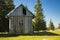Poor rustic wooden cabin abandoned building in wilderness mountain forest highland plateau environment spring time sunny clear