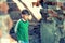 Poor and unhappy orphan boy, stands in a ruined building and looks out with danger. Staged photo