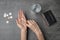 Poor woman counting coins on grey background, top view