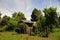 poor wooden house with handmade roof wooden door with flowers and barboles in summer with trees, san martin de los andes argentina