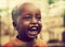 Poor young child laughing with tsetse insects on him. Tanzania, Africa