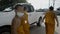 Poor young Thai monks in orange robes walking by modern off-road car