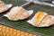 Poorman`s Pancakes with coconut and sugar on tray for sale in Th