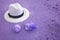 Pop art surreal white straw hat on the sand beach with seashells in purple color