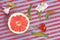 Popart style red grapefruit on a striped background top view