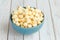 Popcorn in blue cup on white wood table