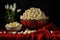 Popcorn in a bowl and white tulips on a dark background, Recreation artistic still life of popcorn opend and closed in a bowl