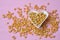 Popcorn corns inside heart bowl on pink background