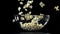 Popcorn drops into a big bowl. Filmed on a high-speed camera at 1000 fps.