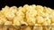 Popcorn in glass bowl on black, rotation, close up