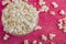Popcorn in a glass plate, on a pink background