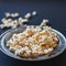 Popcorn in a metallic plate on a dark painted matte surface