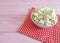 Popcorn plate natural , red napkin traditional in a polka dot pink wooden background with space for text