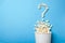 Popcorn is poured in the shape of question mark from white paper cup on blue background. How to choose good movie to watch