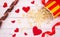 Popcorn, red hearts and ribbon on a white wooden background. valentine`s day, movie theater