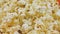 Popcorn rotating close-up, airy popped corn snack served at cinema, entertainment. Popcorn background. Popcorn spins