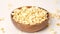 Popcorn tossed in a wooden bowl on a white background. Slow Motion video. Close up top view