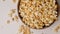 Popcorn tossed in a wooden bowl on a white background. Slow Motion video. Close up top view