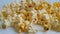 Popcorn on a white background drops, slow-motion shot