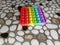 popit toys, with rainbow colors on the tiled floor