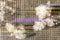 Poplar fluff as white cotton lies in pieces on a black checkered surface, with colored stripes from the lens, lilac and yellow,