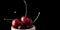 Popsicle with fresh cherries on a dark background, dynamic shot with action, splash, water drops and bokeh. Fresh fruit floating