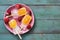 Popsicle with orange slices on a pink plate, frozen strawberries. Green rustic background. Top view, place for text. Summer desser