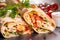 Popular arabic turkish fastfood doner shawarma roll with meat and vegetables on dark background