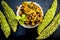 Popular dish for serving in lunch i.e. Bitter gourd with spices and vegetables on wooden surface in a glass plate with raw karela,