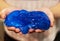 A popular, fashionable, elastic anti-stress toy in the palms. A young teenage girl is holding a blue sticky slime, a children`s st