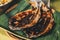 Popular Filipino dish of two grilled milkfish on aromatic banana leaf during celebration.