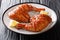 Popular food sticky chicken quarter legs with sesame seeds served with lemon closeup on a plate. horizontal