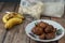 Popular Malaysian fritter snack deep fried banana balls or locally known as Cekodok Pisang in a plate over wooden background